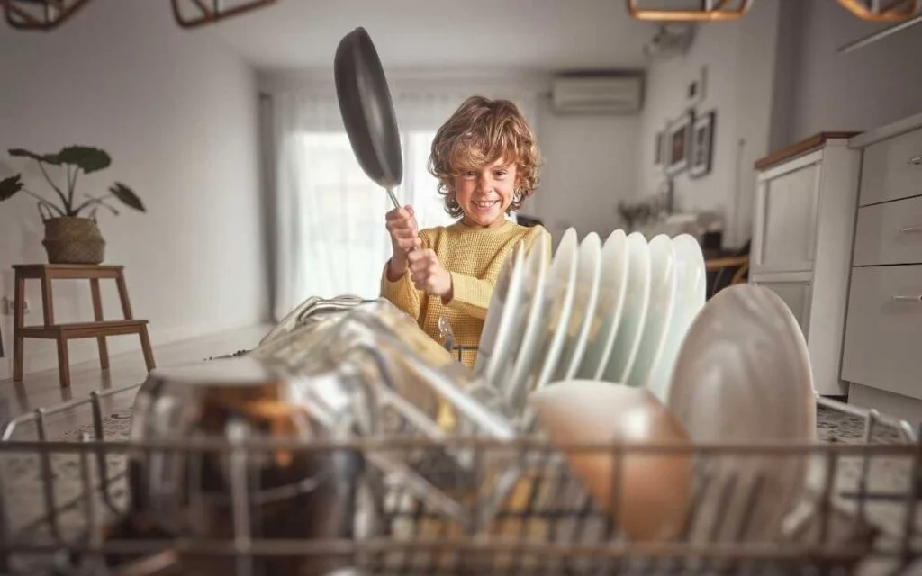 Boy Holding HexClad Pans near Dishwasher