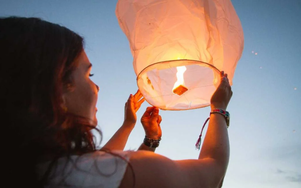 5. What Happens to Lanterns After They Are Released Woman Releasing Lanterns in Air